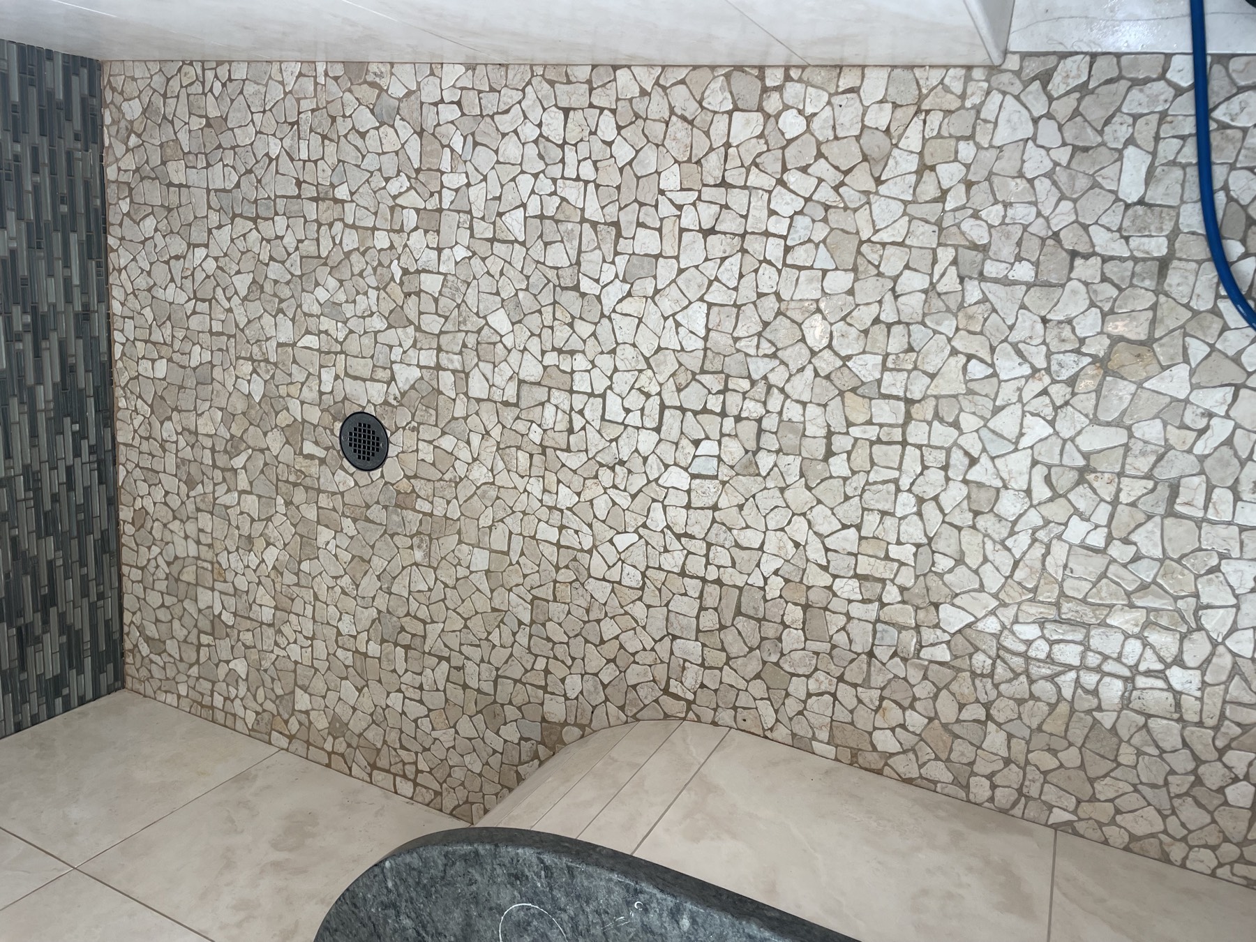 Stone-mosaic shower floor — before
